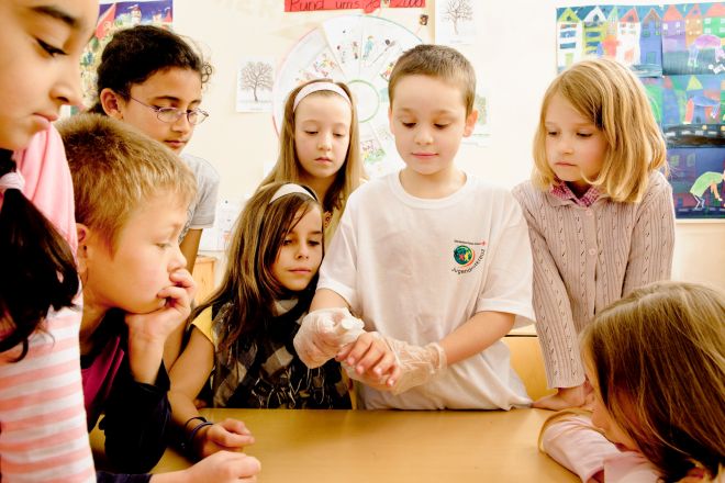 Eine Gruppe von Kindern steht in einem Klassenraum. 